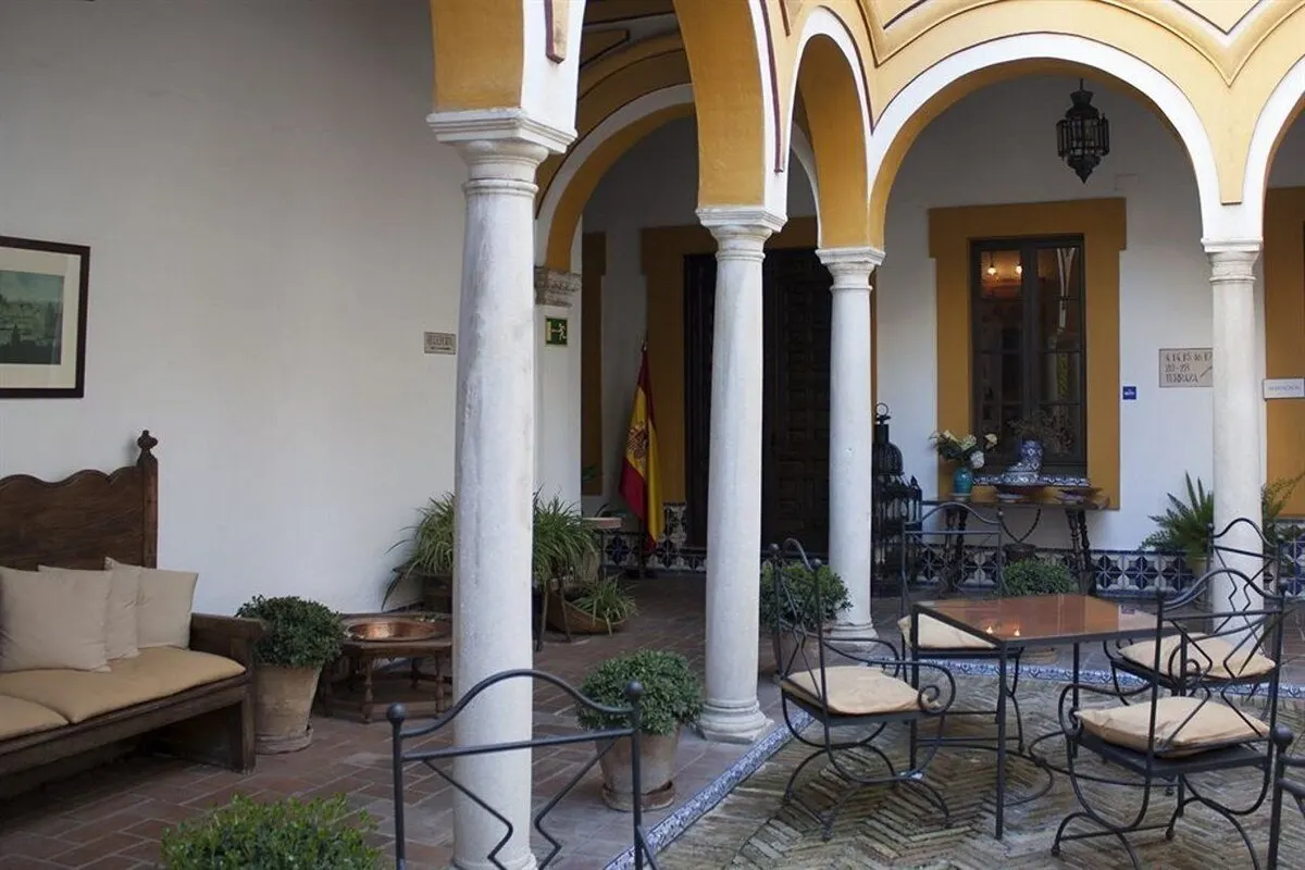 Arcaded courtyard with columns and wrought-iron furniture at Casa Imperial